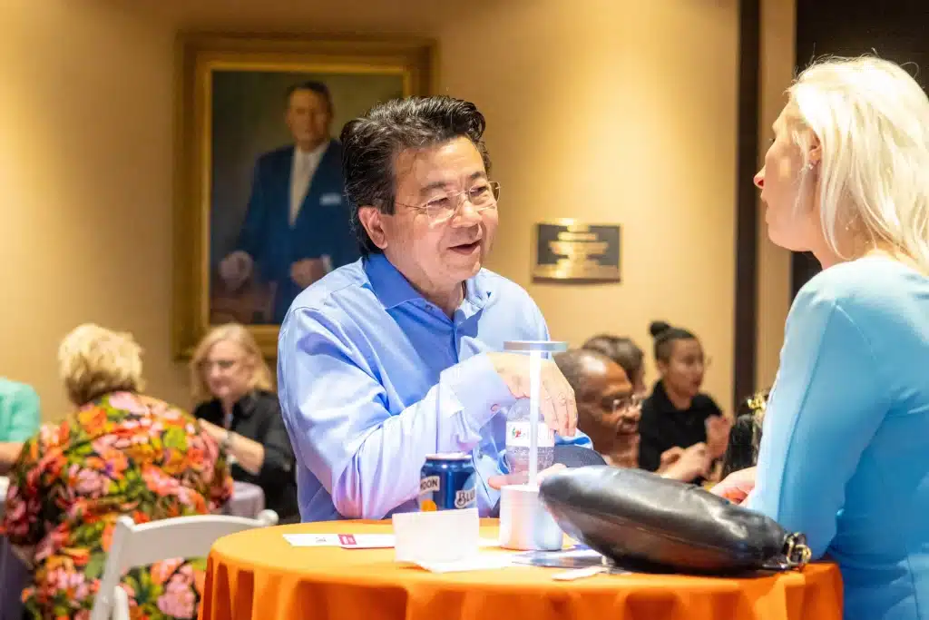 Two attendees talk beside a cocktail table at a Life Science Oklahoma networking event.