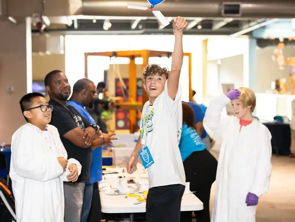 Students in lab coats take part in a hands-on science demonstration during Innovation Week.