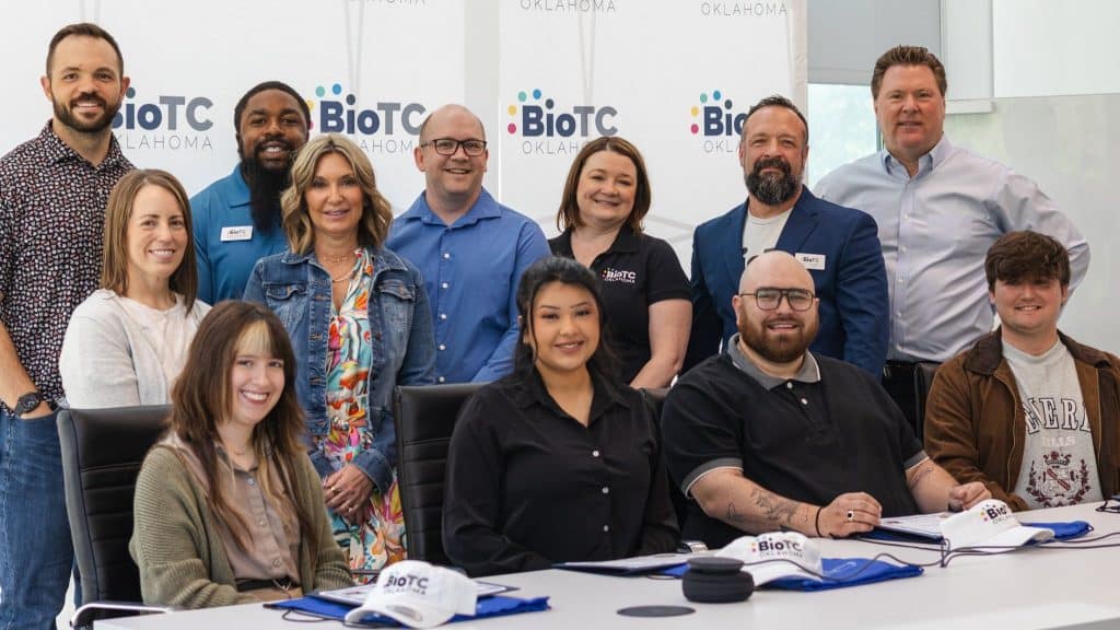 BioTC's first graduating cohort and program team pose together in front of a BioTC Oklahoma backdrop.