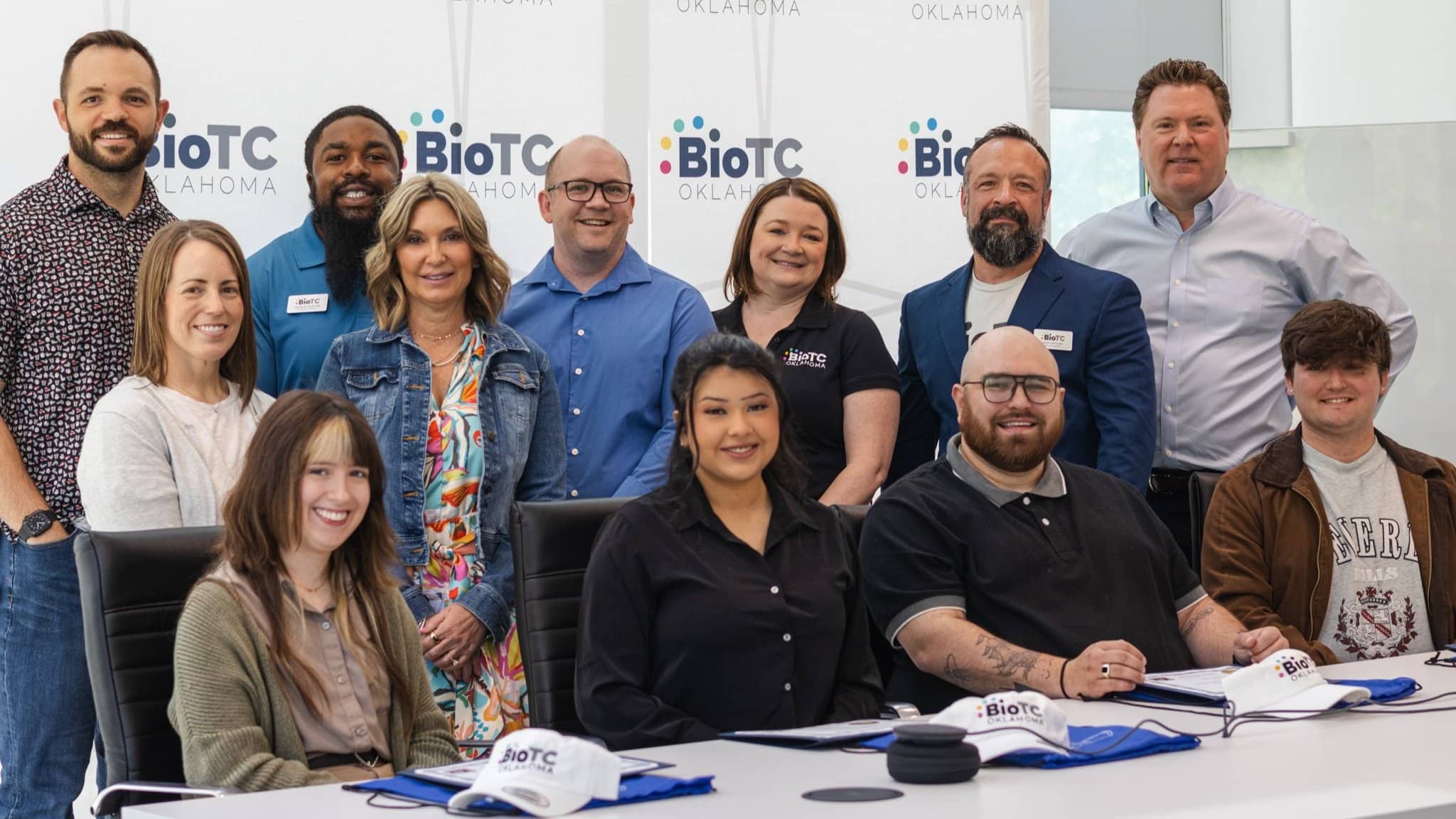 BioTC's first graduating cohort and program team pose together in front of a BioTC Oklahoma backdrop.