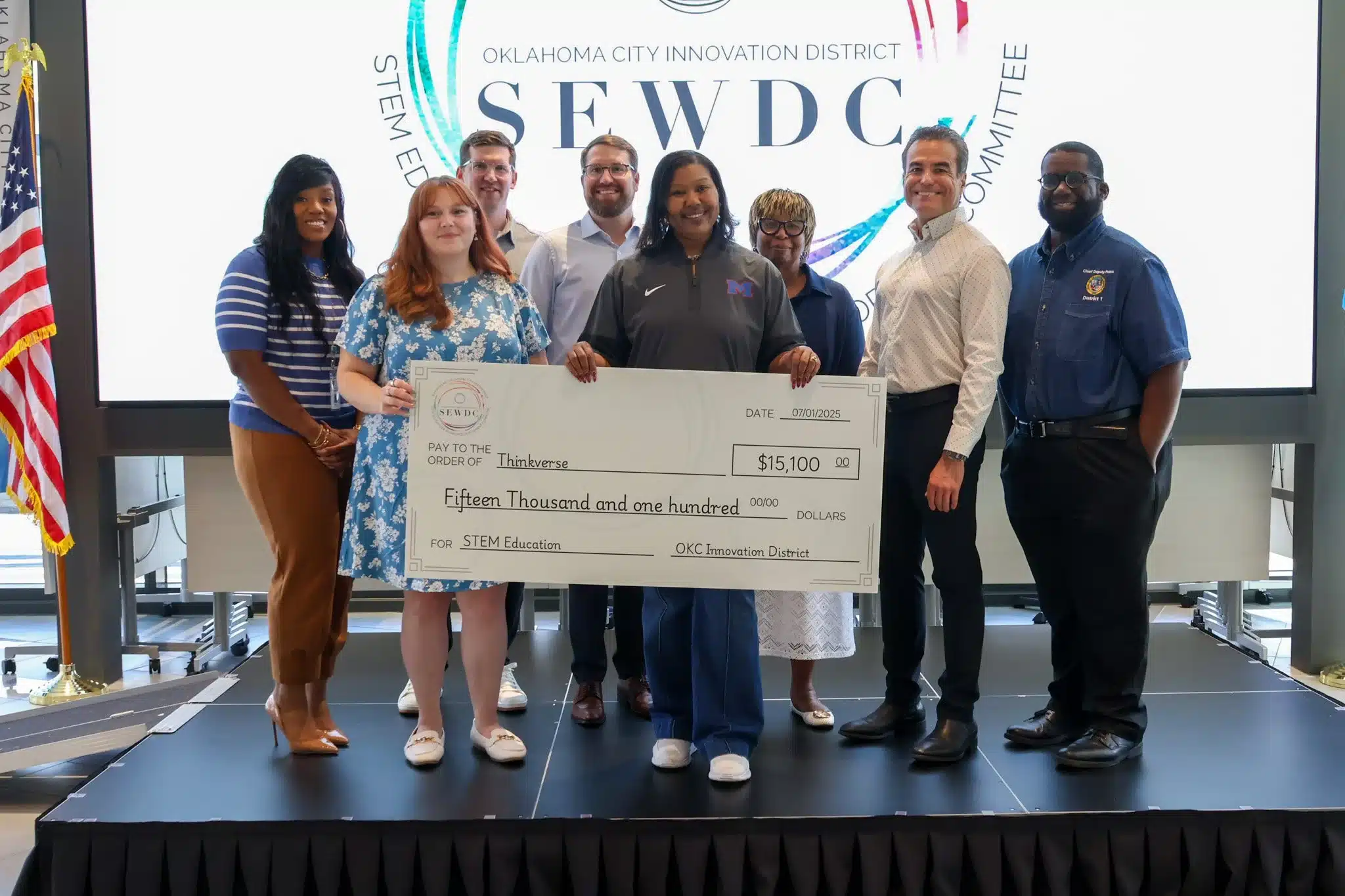 STEM education grant recipients hold an oversized $15,100 check at an Oklahoma City Innovation District presentation.