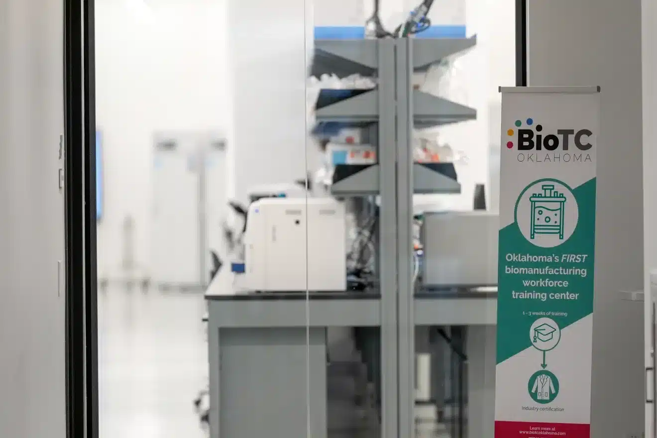 BioTC Oklahoma sign beside laboratory equipment at the biomanufacturing workforce training center.