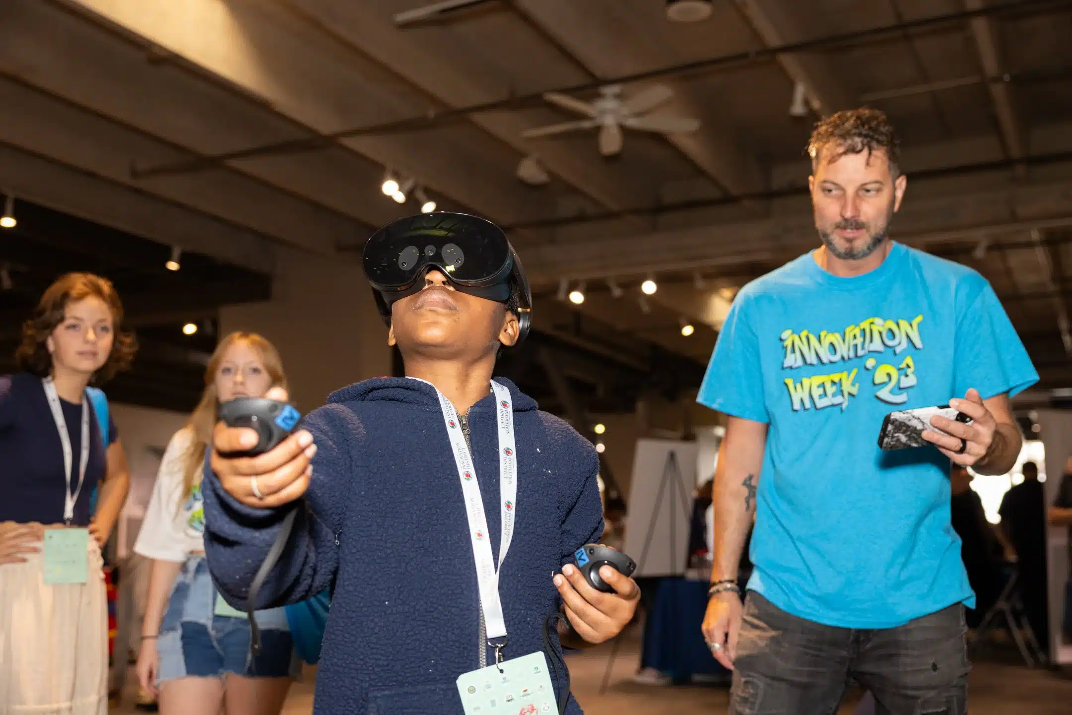 A student uses a virtual reality headset and controllers with an instructor during Innovation Week.