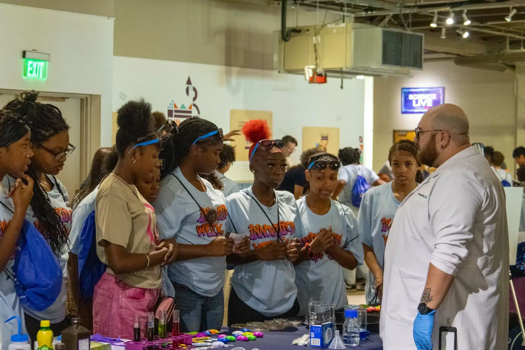 Students gather around an instructor's science demonstration during Innovation Week 2025.