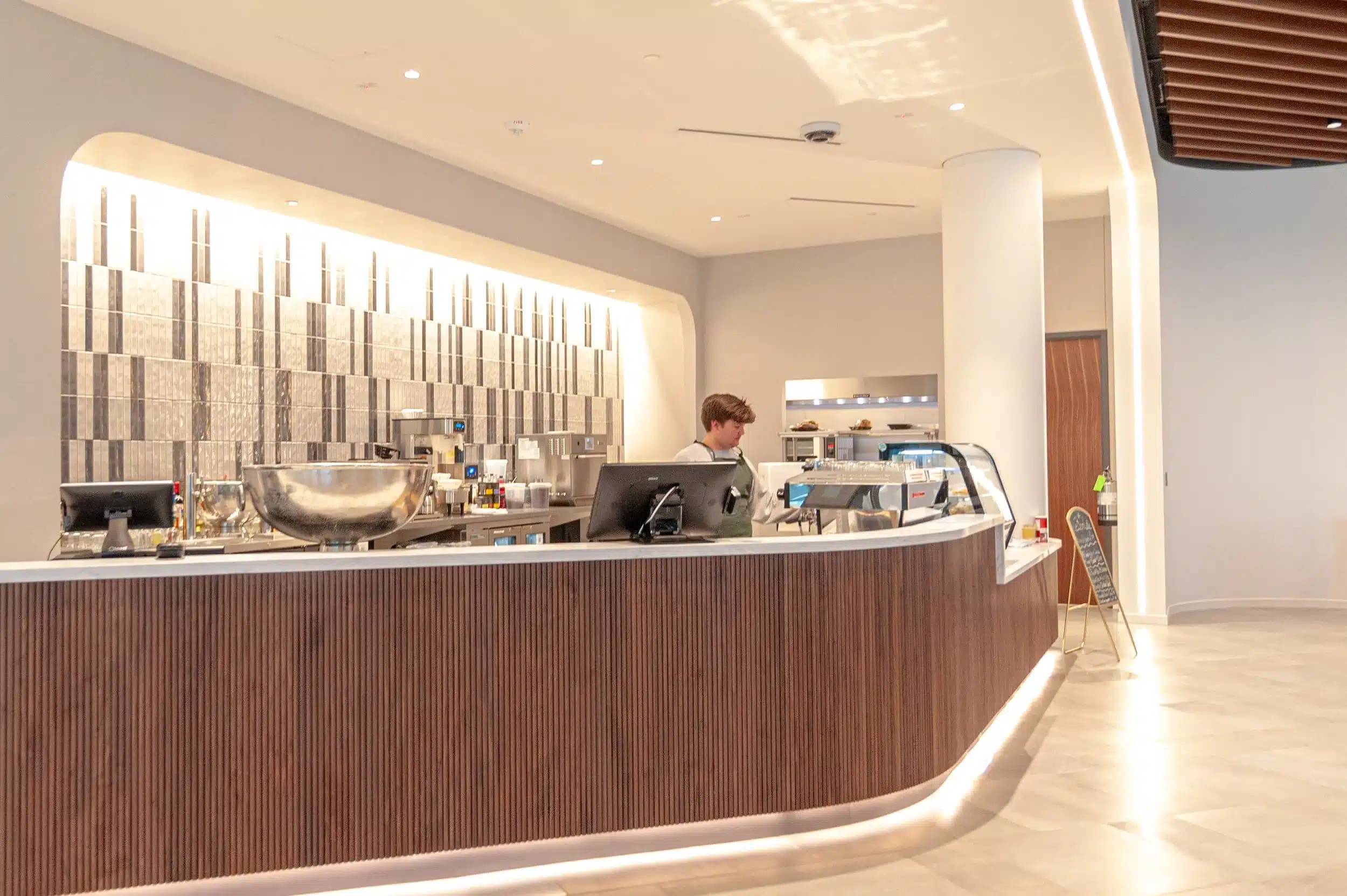 Curved wood-fronted coffee counter at Elemental Coffee inside Innovation Hall.