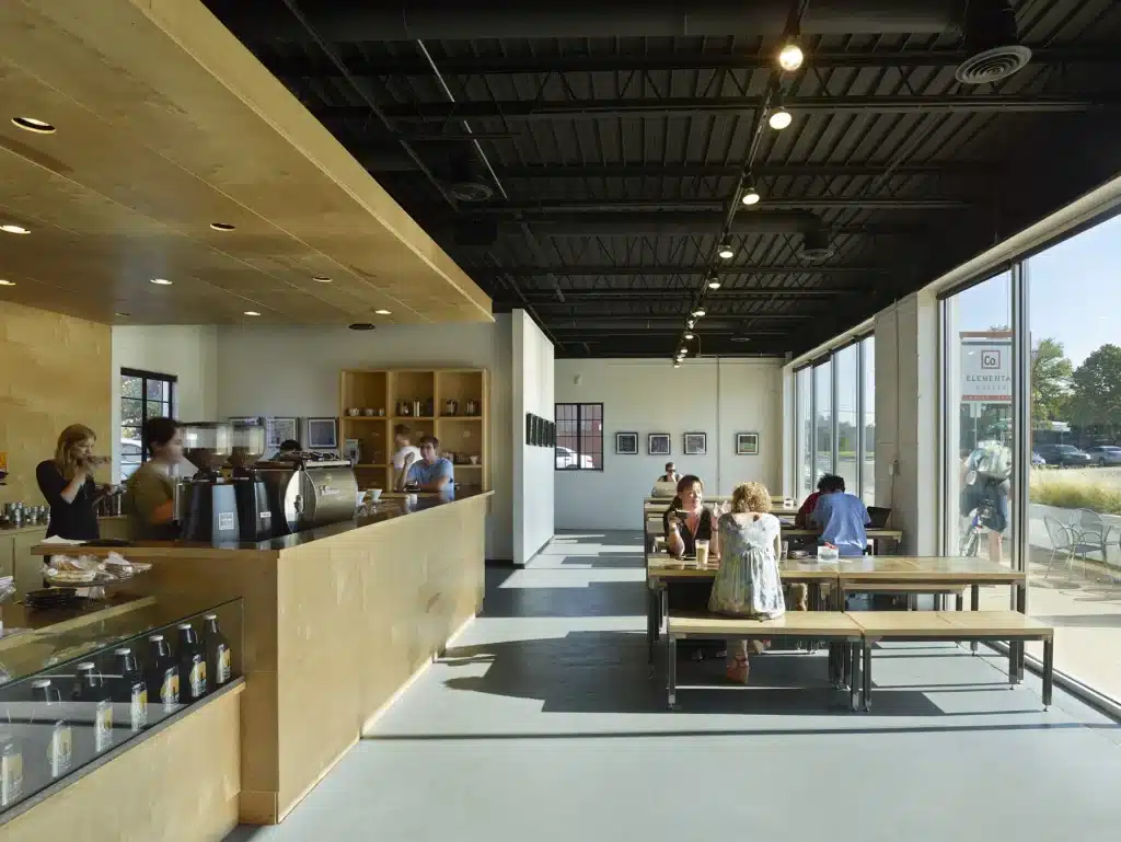 Customers sit at tables beside the coffee bar inside the original Elemental Coffee shop.