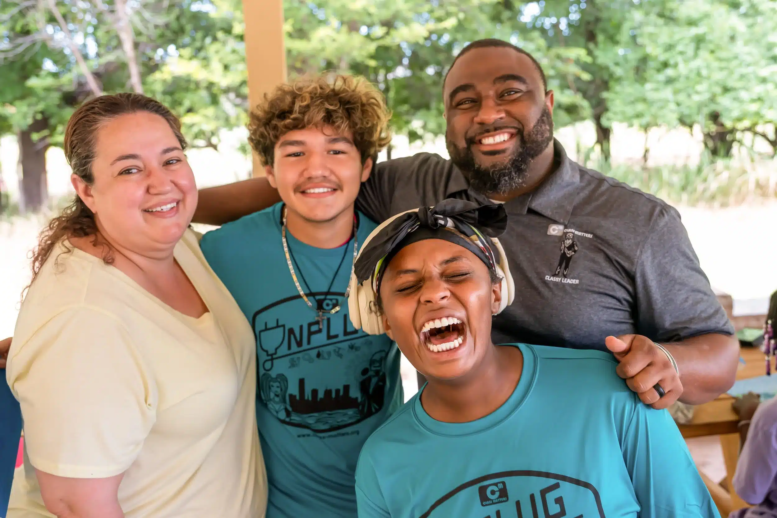 Four participants smile together outdoors at a Class Matters event.