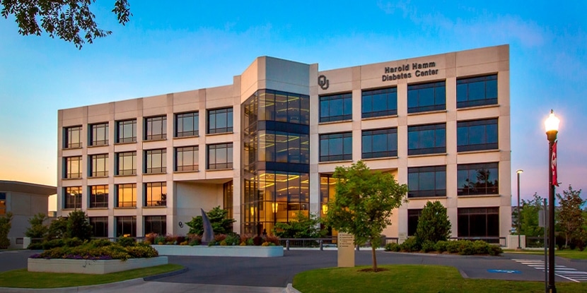 Harold Hamm Diabetes Center building and landscaped entrance at dusk.