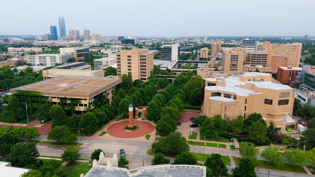 Aerial view of the OU Health campus, tree-lined walkways, and surrounding Oklahoma City buildings.