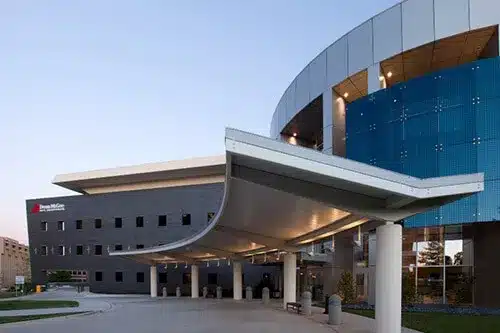 OU Health Dean McGee Eye Institute entrance beneath a curved canopy.