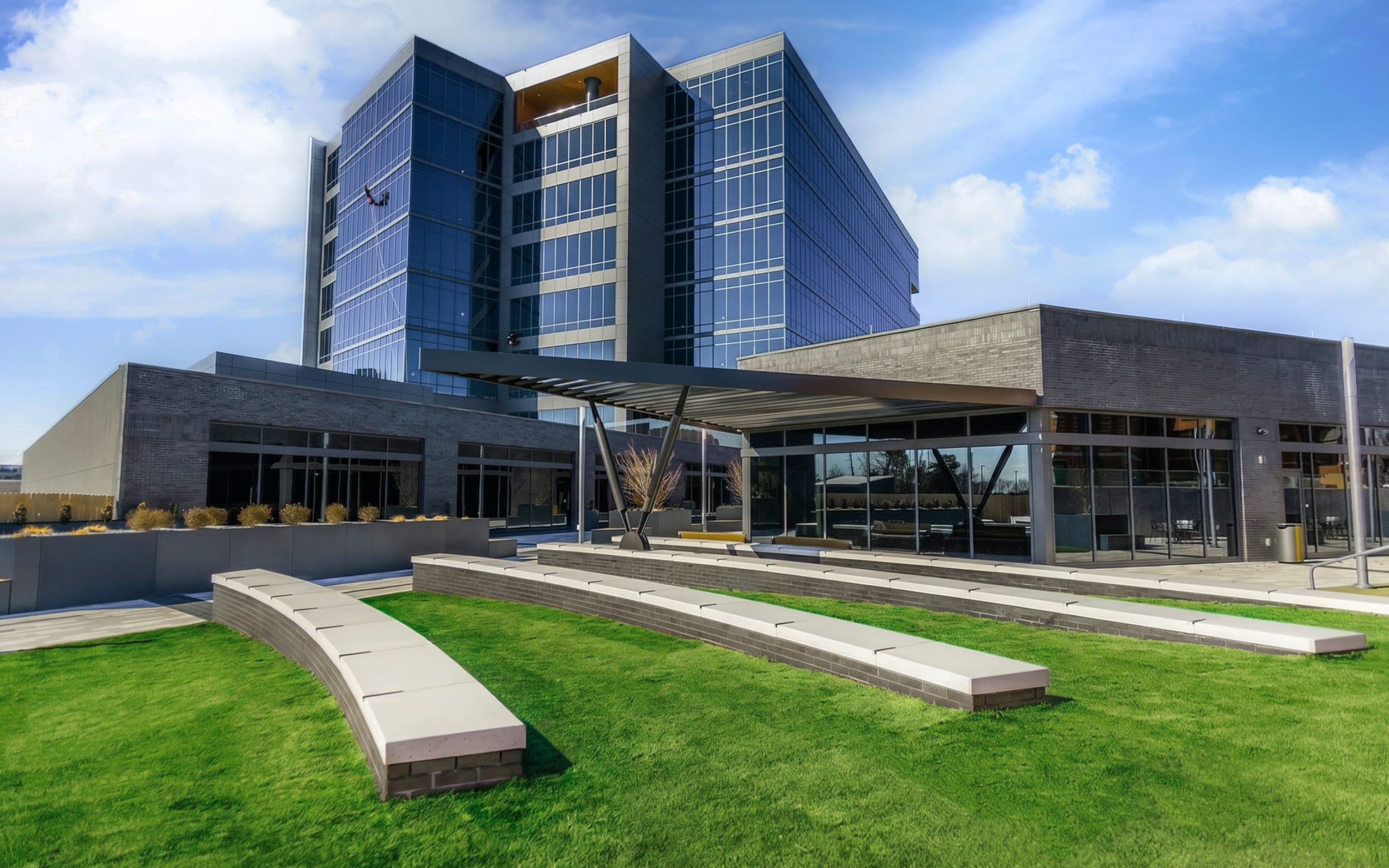 Innovation Hall and The Tower at Convergence overlook a green lawn with curved concrete benches.