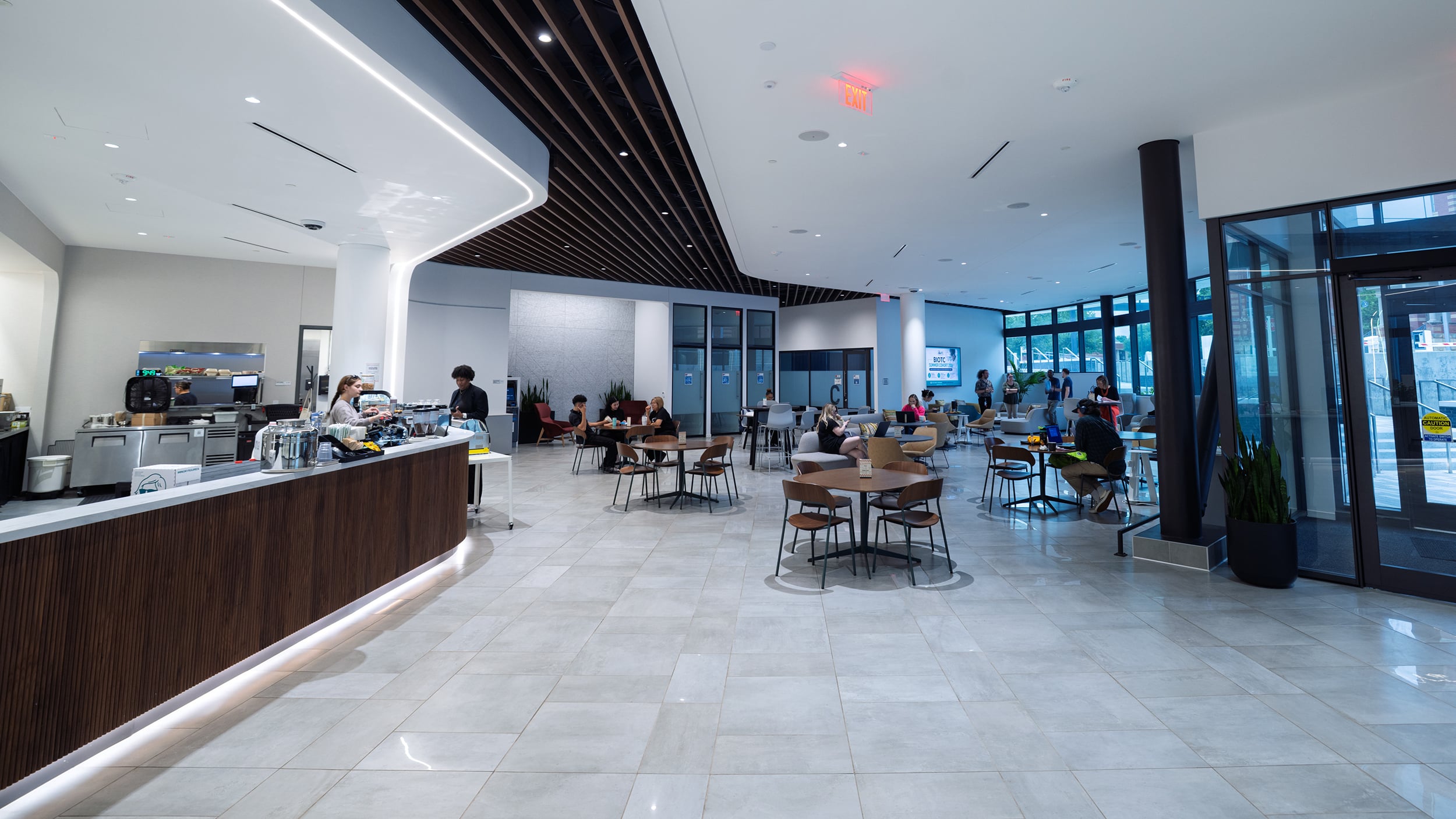 Wide view of Innovation Hall’s coffee counter, café seating, and glass-lined lobby.