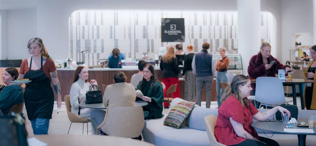 Guests gather around tables and the Elemental Coffee counter inside Innovation Hall.
