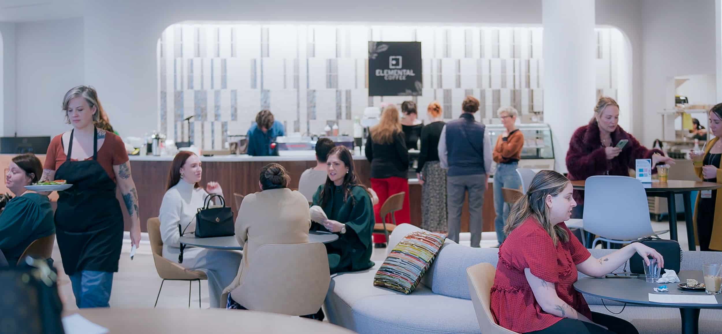 Guests gather around tables and the Elemental Coffee counter inside Innovation Hall.