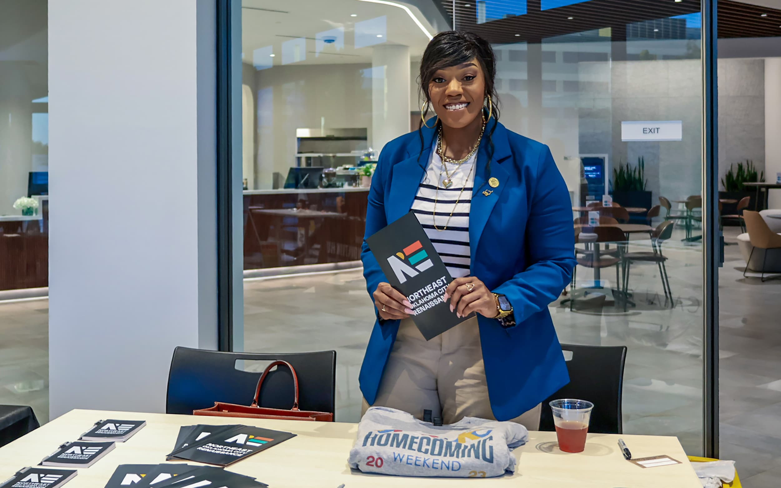 An event participant stands behind an information table at Innovation Hall.