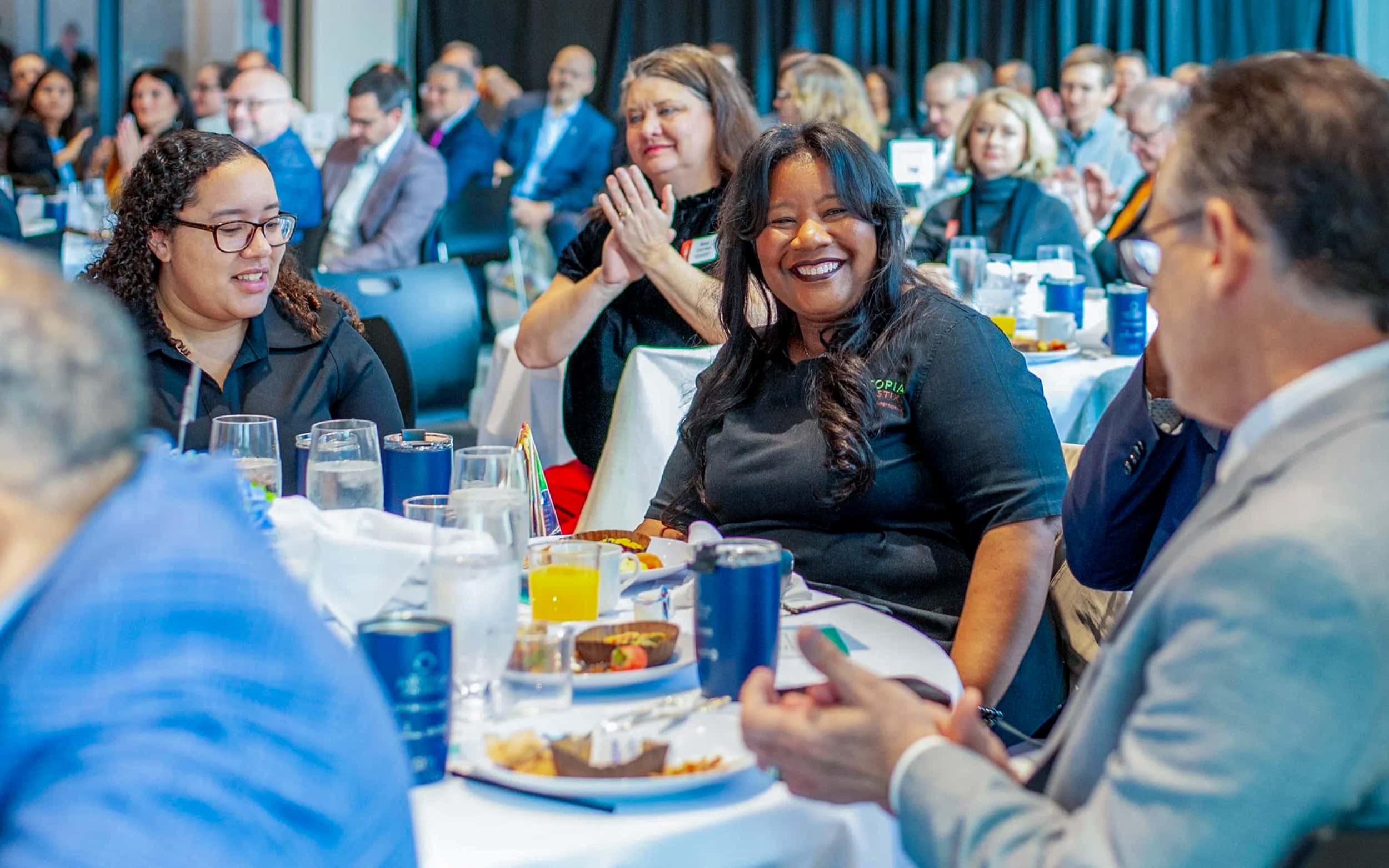 Guests applaud and smile at tables during the Oklahoma City Innovation District Annual Breakfast.
