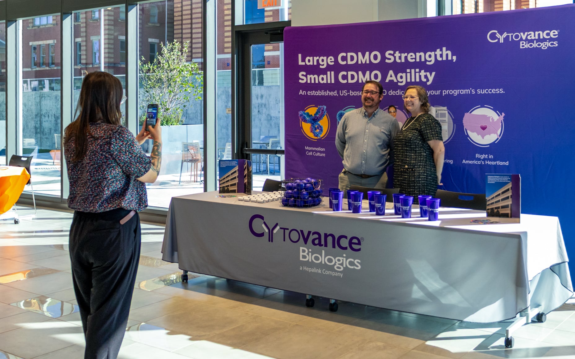 Visitors speak with Cytovance Biologics representatives at a Bio Week exhibit table.