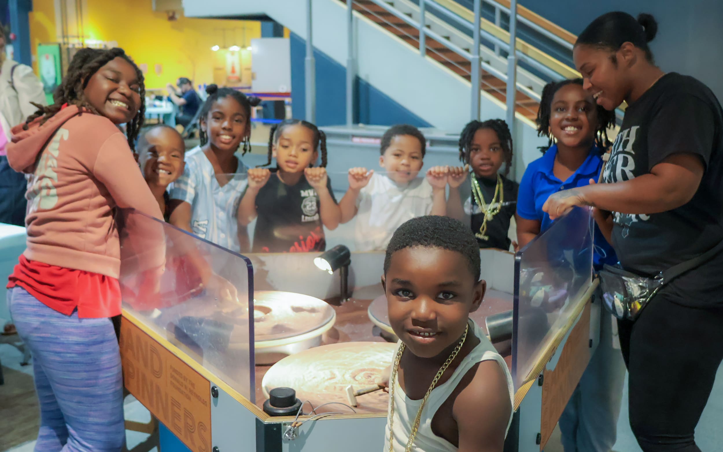 Families gather around a hands-on science exhibit during a community event.