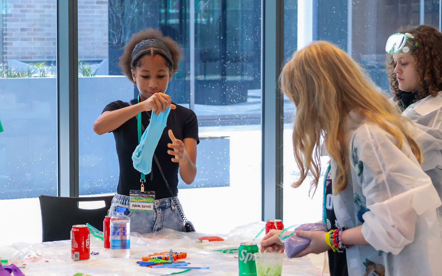 Children stretch blue slime during a hands-on science activity at Innovation Hall.