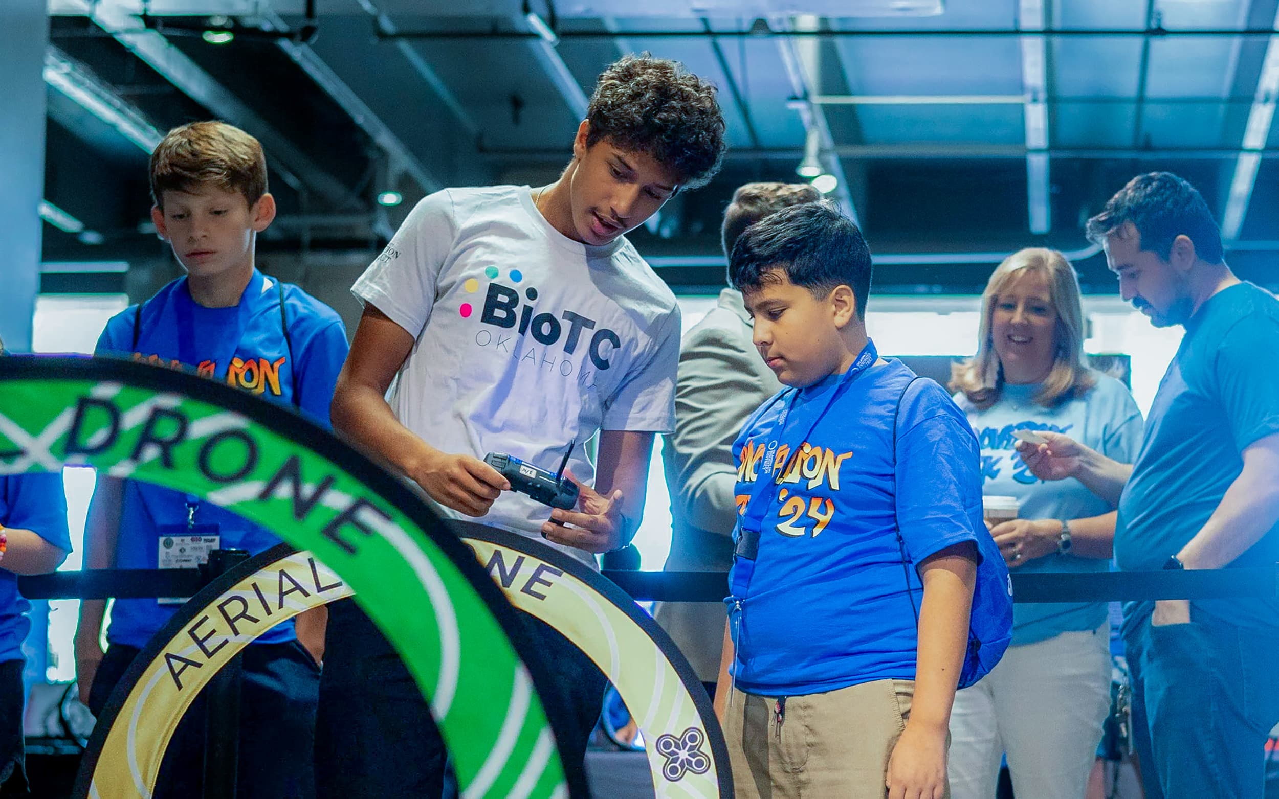 An OKCPS student learns to fly a drone through an obstacle course with a student instructor.