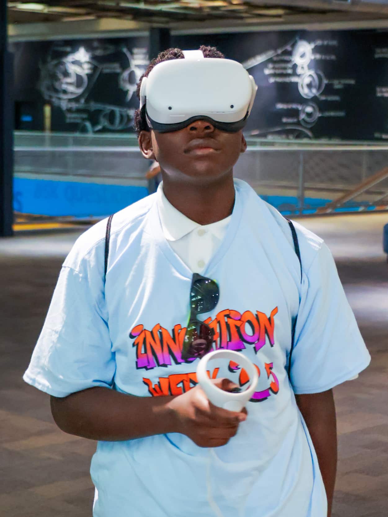 A student tries a virtual reality headset and handheld controller during Innovation Week 2025.