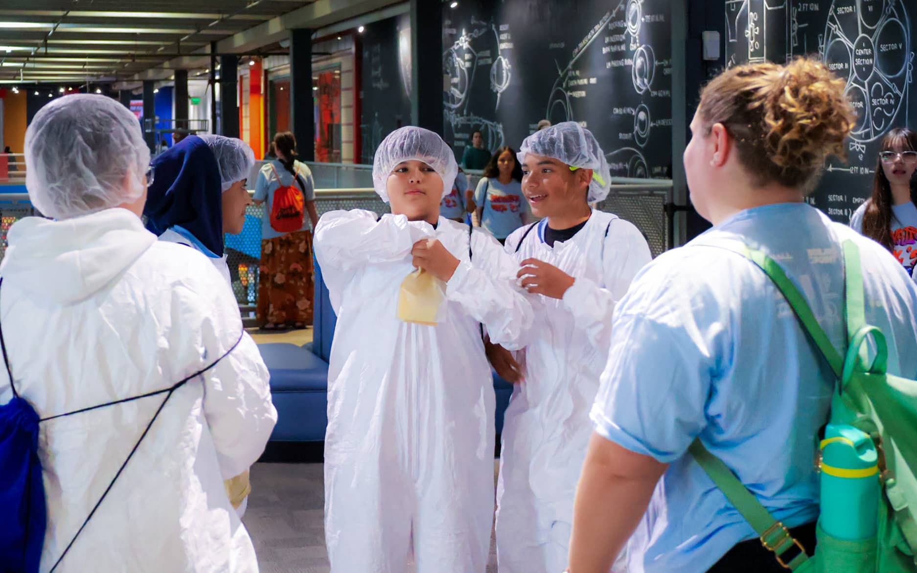 Students wearing protective gowns and hair covers participate in an Innovation Week activity.