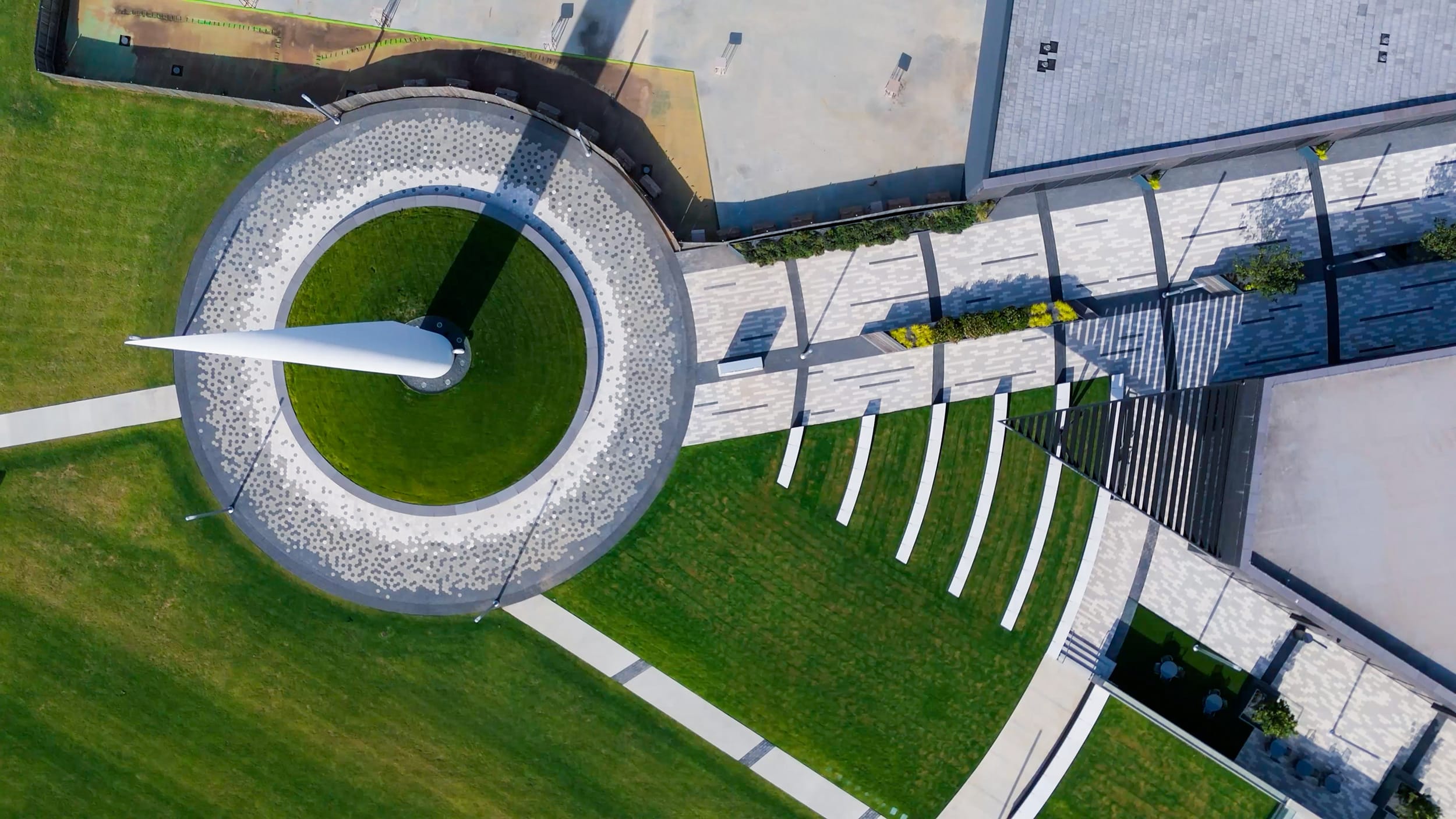 Overhead view of the Beacon of Hope sculpture, circular walkway, and green lawn in Stiles Park.