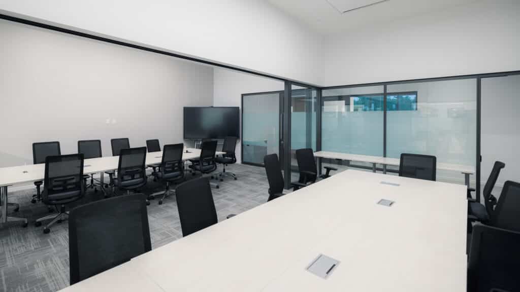 Innovation Hall meeting rooms with glass partitions, conference tables, rolling chairs, and monitors.