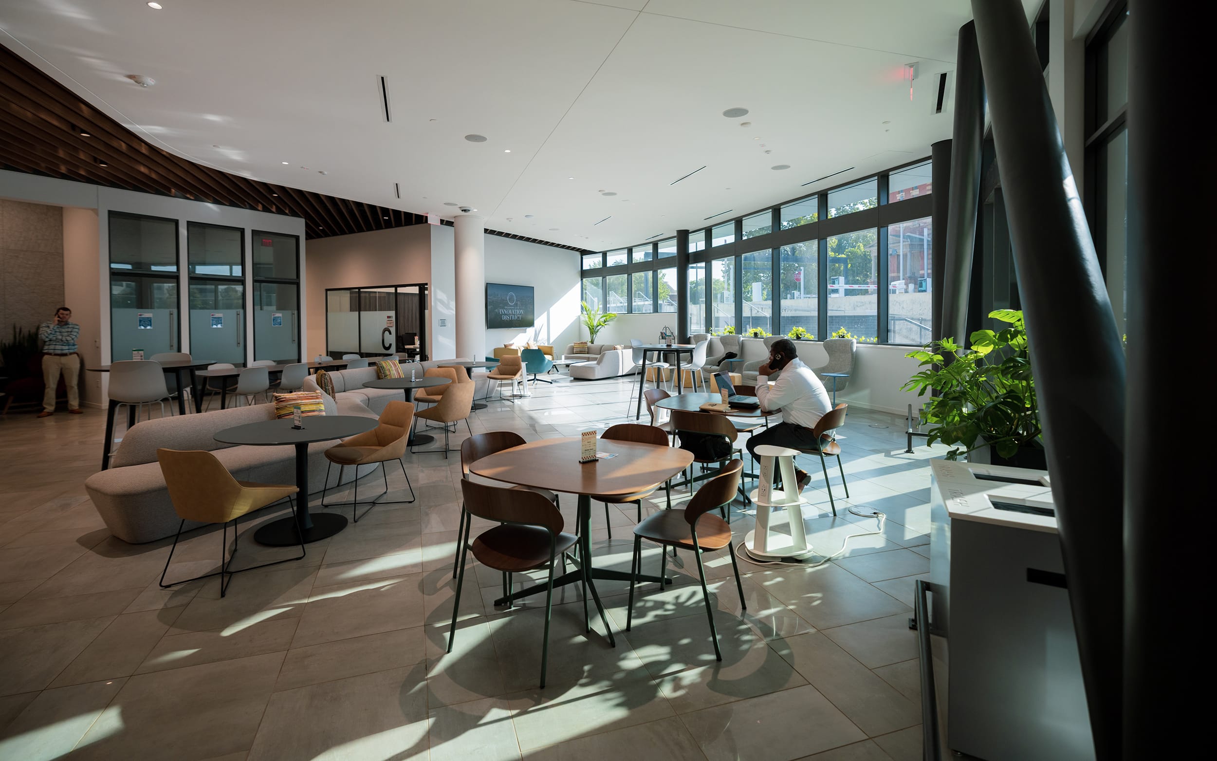 Innovation Hall’s open café and lounge area with tables beside floor-to-ceiling windows.