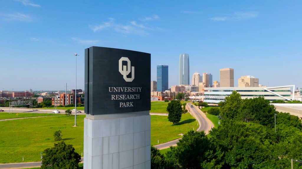 University Research Park entrance sign with the Oklahoma City skyline in the distance.