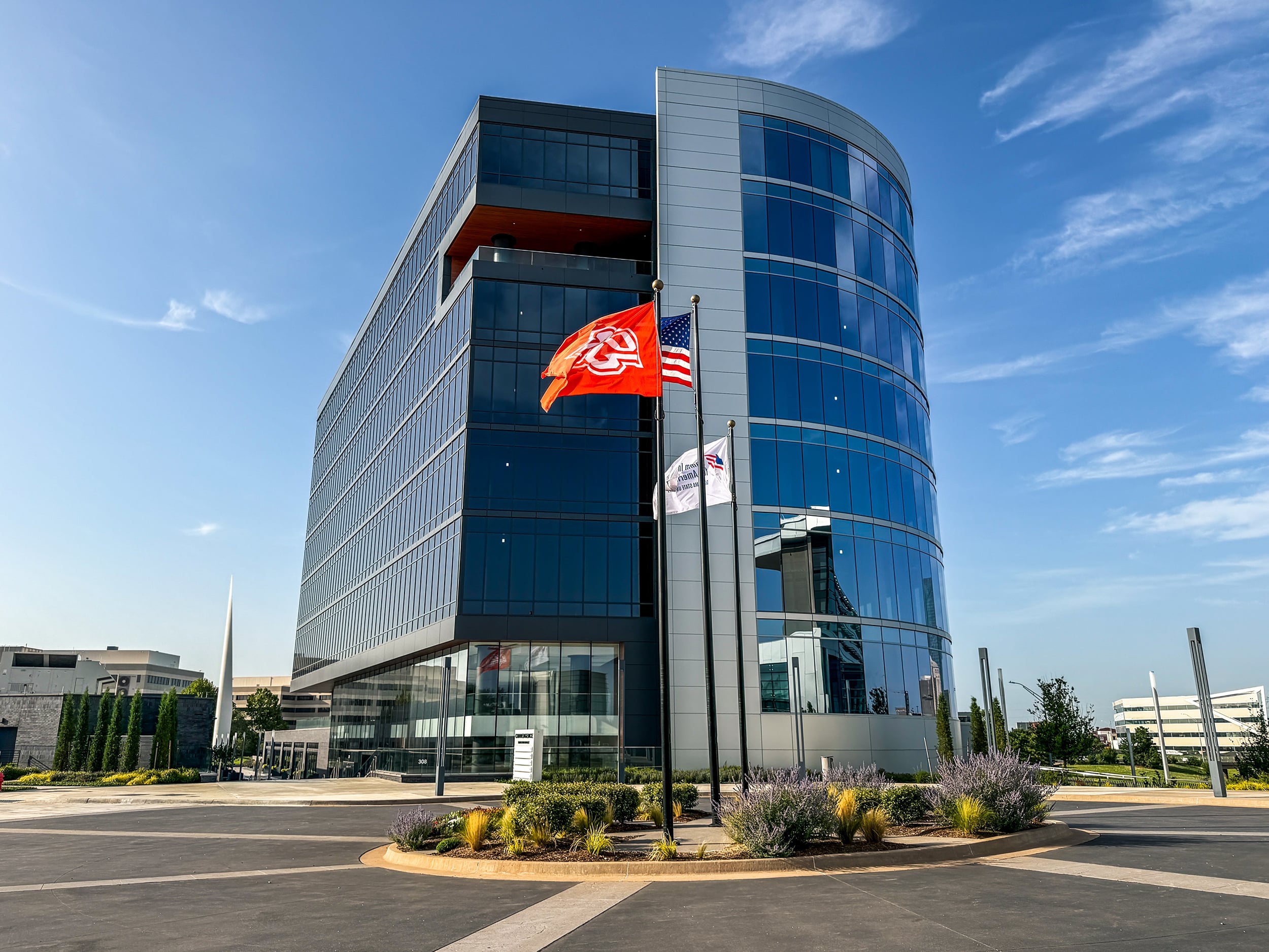 The Tower at Convergence with its curved glass façade and flags near the entrance.